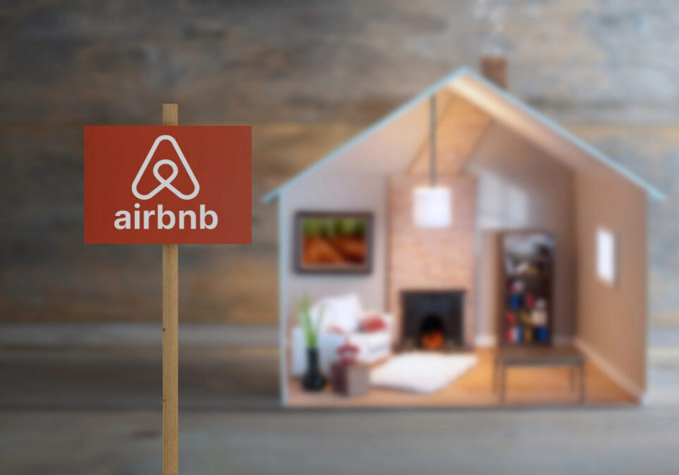 Airbnb sign in front of a small house representing short term rental property